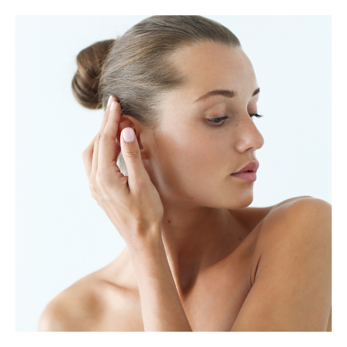 Fata care isi atinge cu mana urechea inainte de otoplastie